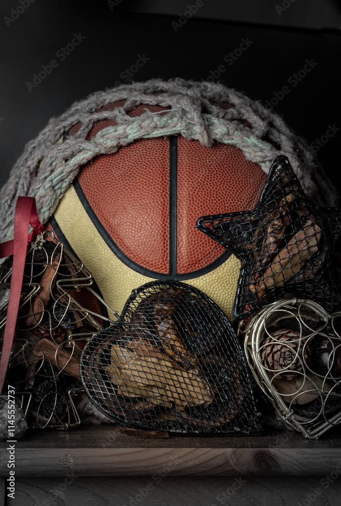 Basketball ball inside of mesh net string decoration with Christmas tree mesh case, Heart mesh case and Star mesh case on Dark background. Christmas-themed event basketball idea, sports play christmas