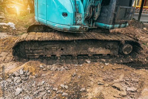 A yellow excavator focuses on its metal bucket teeth,digging soil at a construction site.This earth-moving machinery,including loaders and backhoes,is essential for excavation and earthwork projects photo