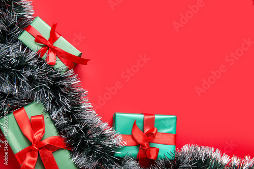 Composition with tinsel and Christmas gifts on red background