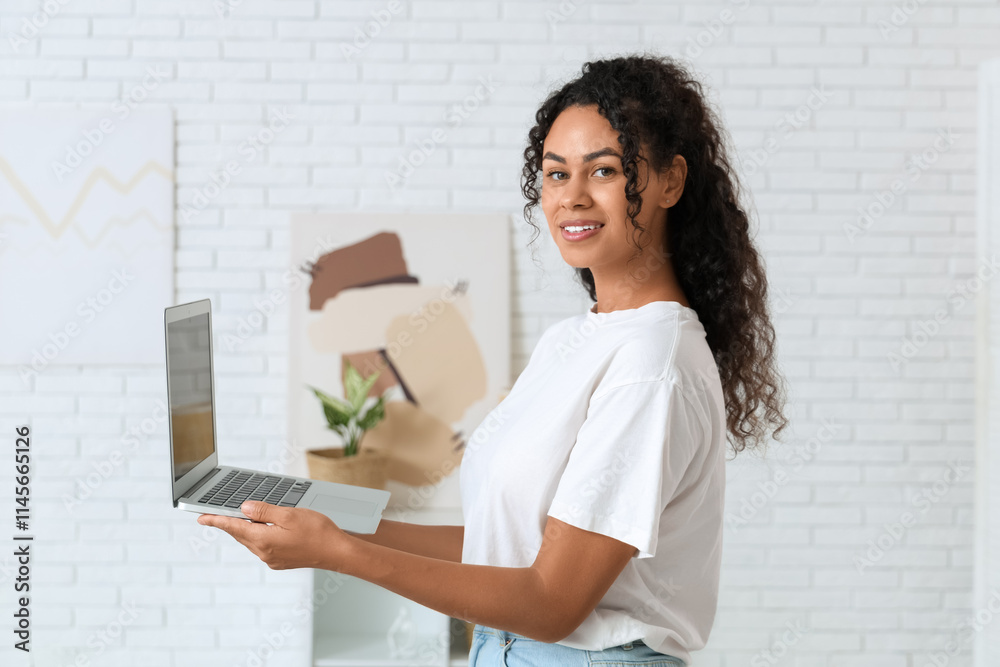 Pretty young African-American woman with laptop at home Pretty young African-American woman with laptop at home