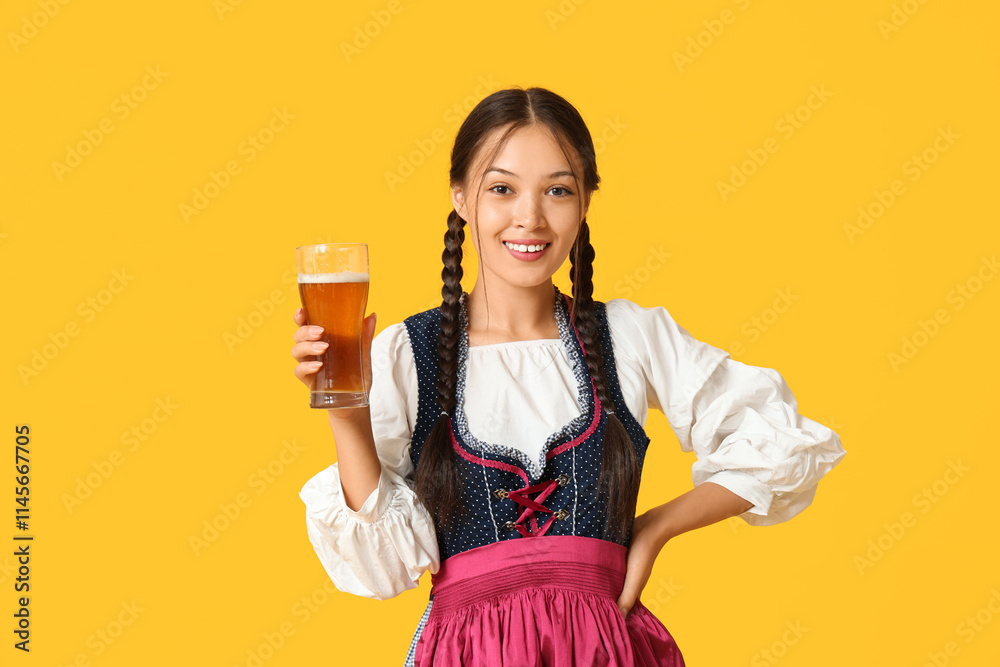 Young Octoberfest waitress with glass of beer on yellow background Young Octoberfest waitress with glass of beer on yellow background