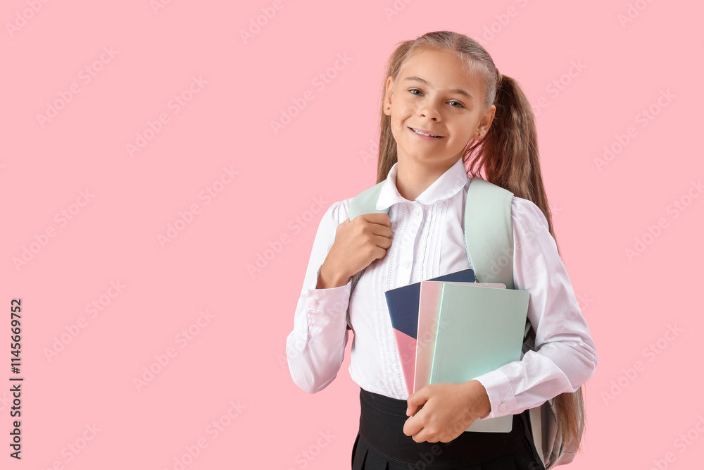 Cute little girl in school uniform with notebooks on pink background Cute little girl in school uniform with notebooks on pink background