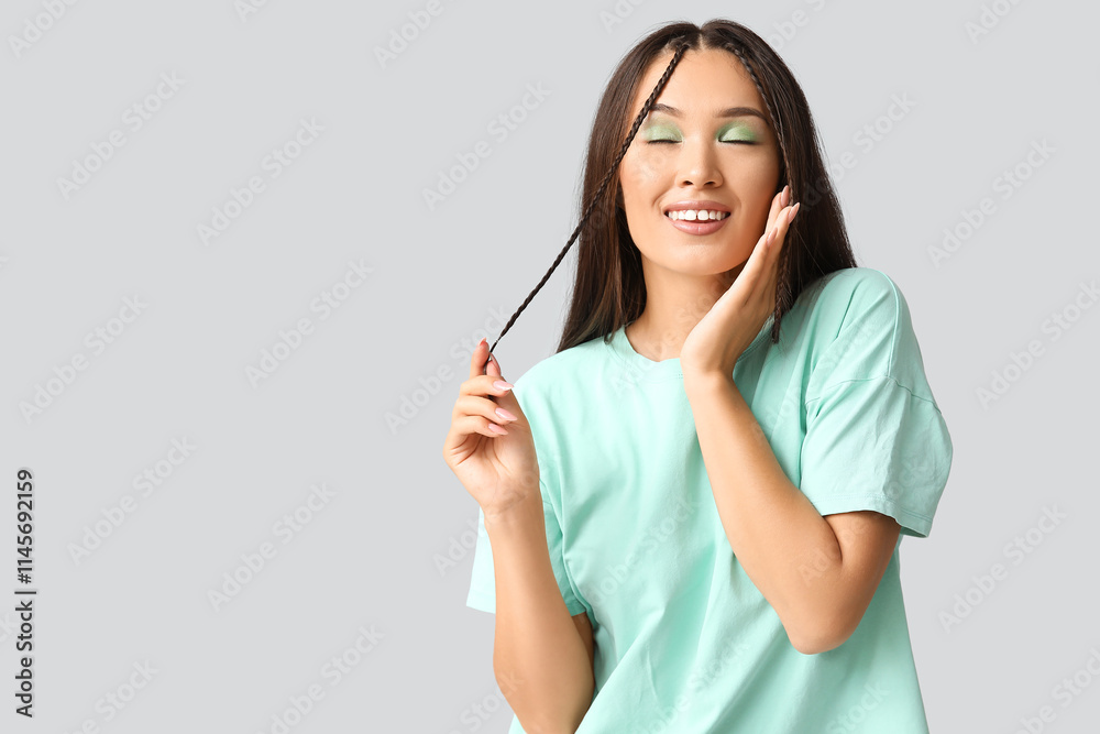 Happy young Asian woman with stylish mint makeup on grey background Happy young Asian woman with stylish mint makeup on grey background
