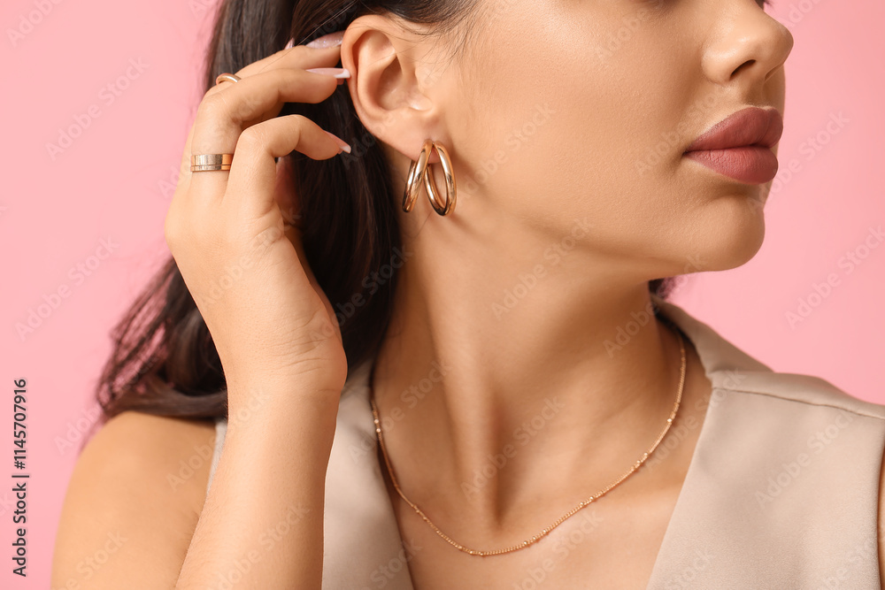 Fashionable young woman in beautiful jewelry on pink background, closeup Fashionable young woman in beautiful jewelry on pink background, closeup