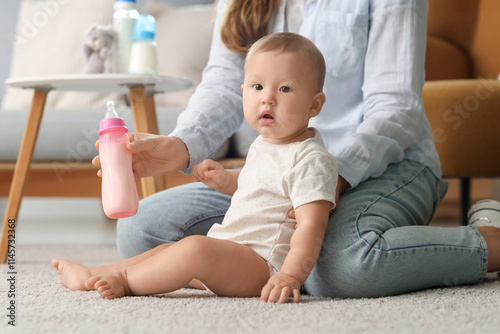 Mother holding baby bottle ...