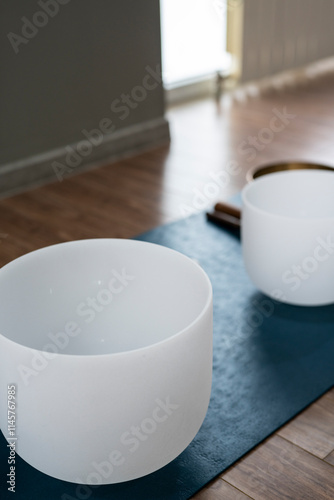 Crystal quartz singing bowls on the floor of a yoga studio.