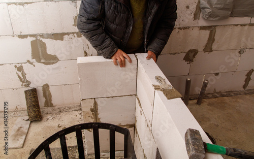 A man is working on a wall with a hammer photo