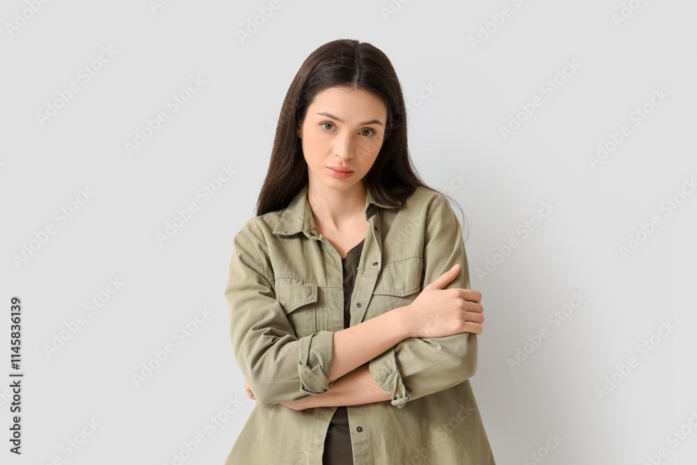 Portrait of worried young woman on light background Portrait of worried young woman on light background