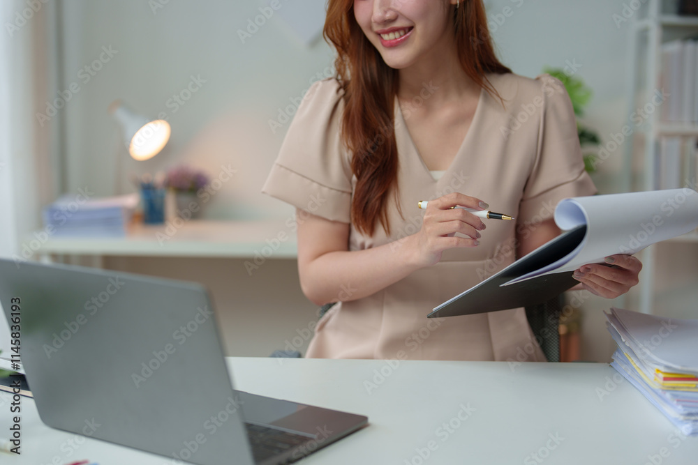 Confident Asian businesswoman working and checking work with laptop, holding files and smiling. Happy and successful Technology and relaxing coffee drinking at modern office. Confident Asian businesswoman working and checking work with laptop, holding files and smiling. Happy and successful Technology and relaxing coffee drinking at modern office.