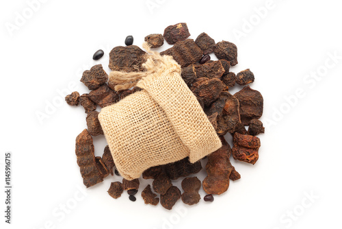 Close-up of organic Shikakai (Acacia concinna) fruits in a jute bag on a heap of shikakai fruits, isolated on a white background. photo