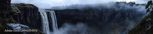 Powerful Cascading Waterfall Over Dark Rocky Cliffs