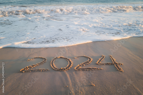 The number '2024' is written in the sand with white waves washing over the shore