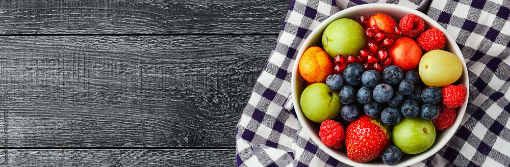 Fresh fruit bowl with vibrant berries and apples on checkered cloth Fresh fruit bowl with vibrant berries and apples on checkered cloth