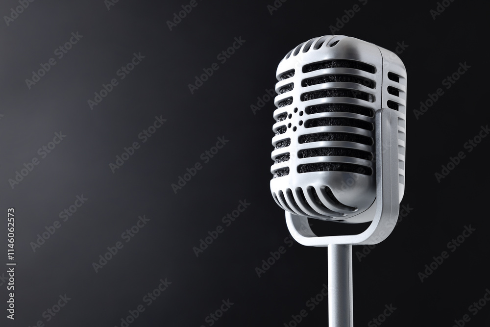 Fototapeta premium Detail of a vintage microphone on dark isolated background