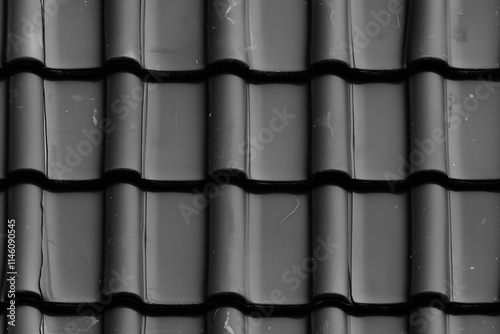 Seamless black ceramic roof tiles arranged in a pattern, showcasing their glossy finish and texture.