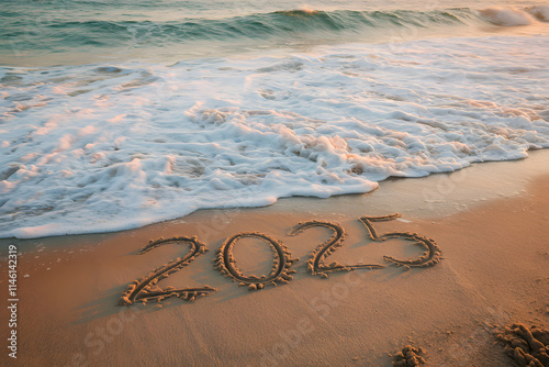 The number '2025' is written in the sand with white waves washing over the shore