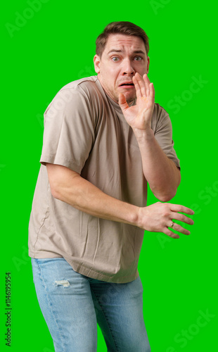 Man expressing fear while standing against a bright green background