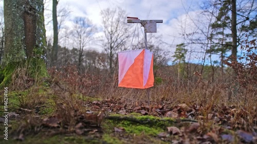 Control Point Scoring Marker at Foot Orienteering Competition Event with International White and Orange Flag photo