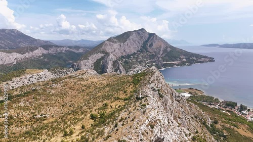 Flying over the mountain ridge towards Omis town in Croatia during summertime