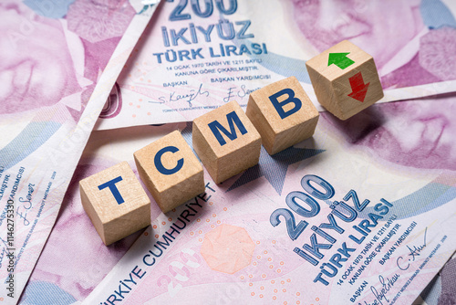 Fototapeta Naklejka Na Ścianę i Meble -  Wooden cubes with TCMB (Turkiye Cumhuriyet Merkez Bankasi) and up-down arrows on 200 TL. The concept of TCMB interest rate hike to curb inflation