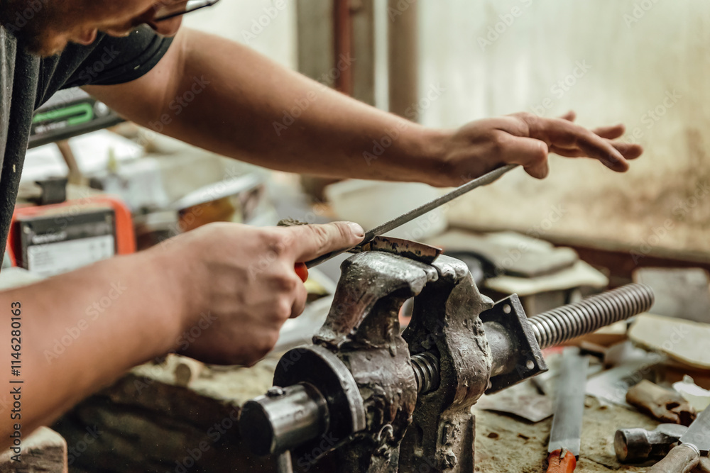 Manual sanding of metal part in vice Manual sanding of metal part in vice