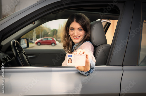 Obraz na płótnie Young woman showing driving license from inside car w salonie