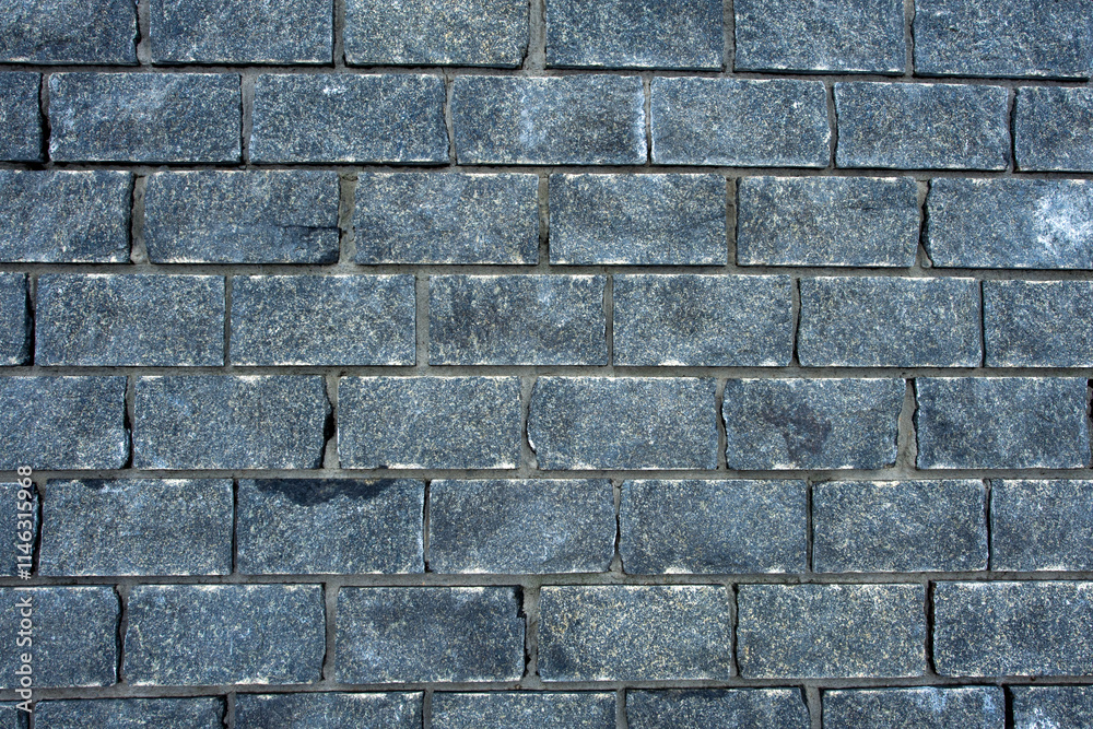 Obraz premium Wall of stones. Brick wall. Gray background with black geometric patterns, of rectangular stones, bricks. Part of a stone wall pattern for background, texture or text. rough grainy stone wall