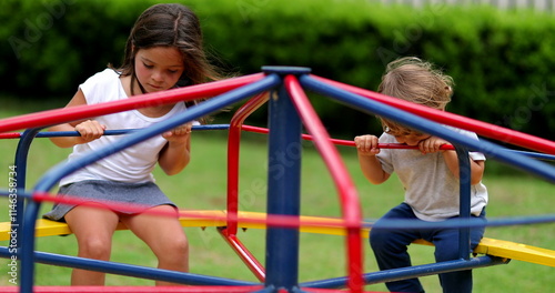 Children playing at playground caroussel. Kids spinning around outdoors