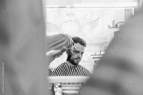 A man is getting his hair cut in a barbershop