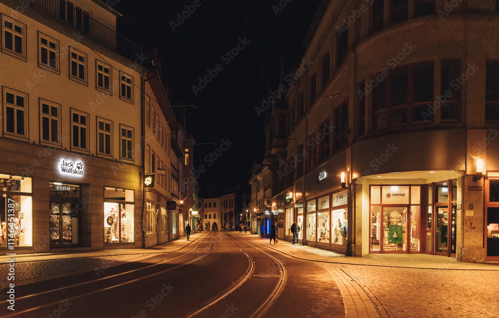 night view of quiet european street with tram tracks illuminated by warm lights and storefronts during winter. High quality photo night view of quiet european street with tram tracks illuminated by warm lights and storefronts during winter. High quality photo