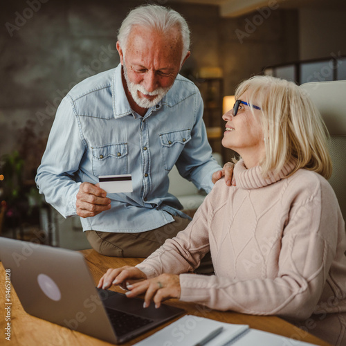 husband and wife shop online on laptop with credit card on wooden table photo