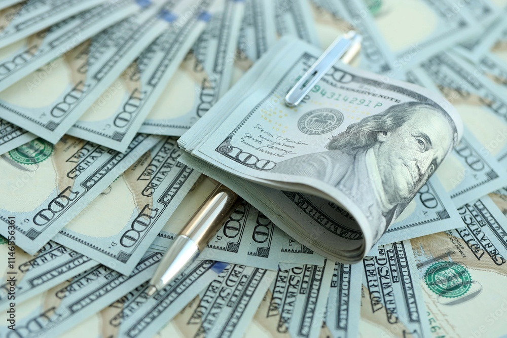 Golden pen clipping big amount of hundred dollar bills US banknotes Golden pen clipping big amount of hundred dollar bills US banknotes