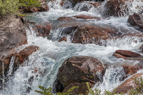 Rocky stream in the foothills of Tierra Del Fuego, just outside Ushuaia, Argentina. Crystal clear water running over boulders, green vegetation on the bank.
 photo