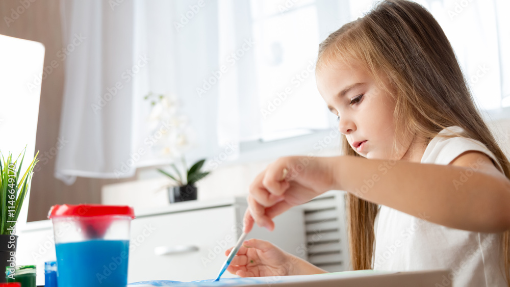 Child girl playing with digital wireless tablet computer on bed at home.