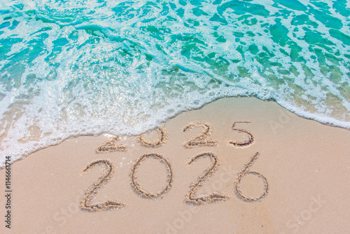 Message Year 2025 replaced by 2026 text written on beach sand background. Good bye 2025 - 2026 happy New Year coming concept.  top view.