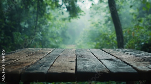 Empty wood table top with blur background of nature lush green forest. The table giving copy space for placing advertising product on the table along with beautiful green forest nature background.  photo