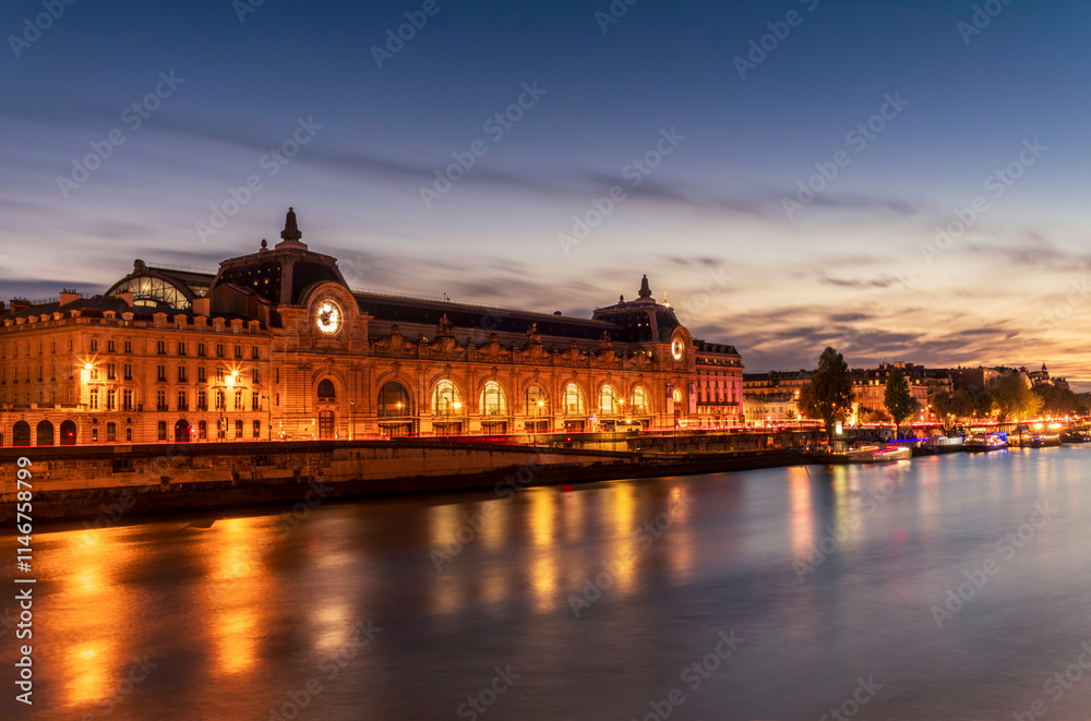 Obraz premium The Orsay museum in Paris at sunset reflecting on the Seine river