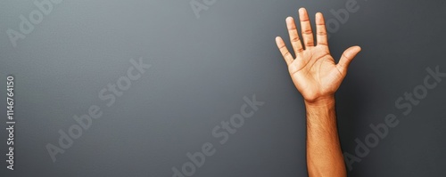 A raised hand against a plain background, symbolizing communication, greeting, or a call for attention.