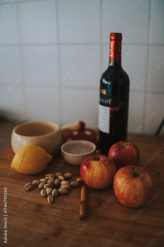 bodegon tradicional con productos naturales como manzanas, limon y pistcahos con una botella de vino de fondo