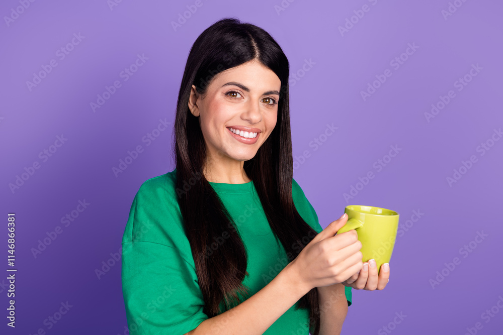 Joyful young woman with green t-shirt holding a mug against a vibrant purple background, symbolizing relaxation and leisure Joyful young woman with green t-shirt holding a mug against a vibrant purple background, symbolizing relaxation and leisure