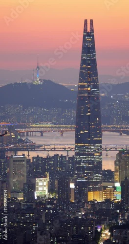 Impressive view of Seoul and Lotte World skyscraper at dusk, patrol helicopter flying low over city. Supertall skyscraper in its full height