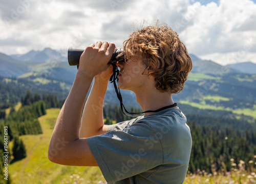 Man with binoculars at the mountain.
Young man using binoculars. Man looking through binoculars at the coast.