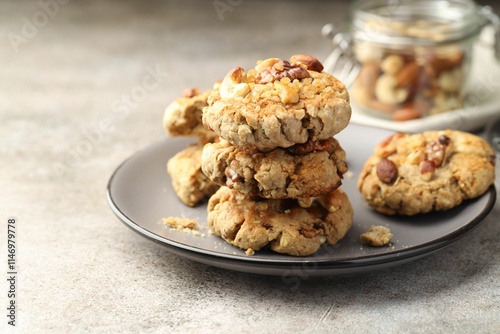 Tasty cookies with nuts on gray textured table, closeup