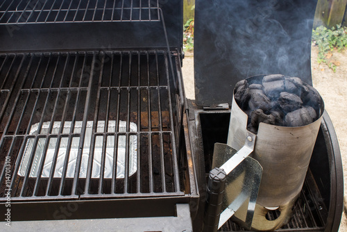 Barbeque smoker with fire starter with coals and smoke