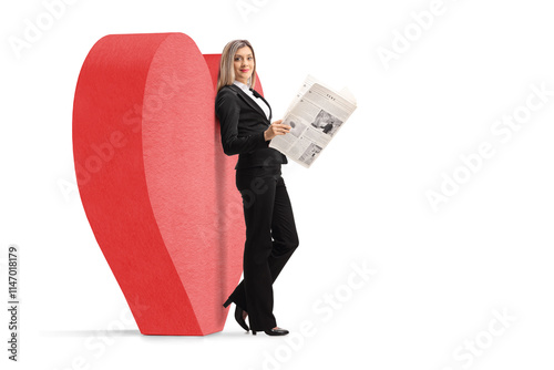 Full length profile shot of a businesswoman reading a newspaper and leaning on a red heart