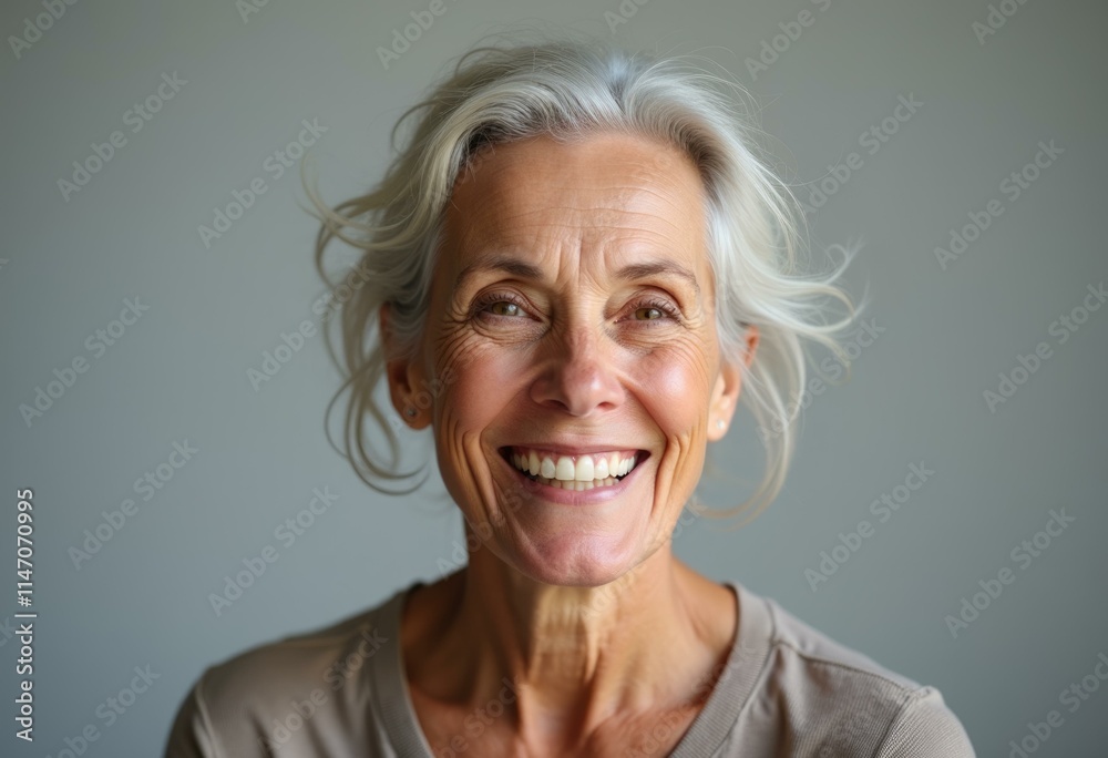 A smiling older woman with gray hair looks directly at the camera. A smiling older woman with gray hair looks directly at the camera.