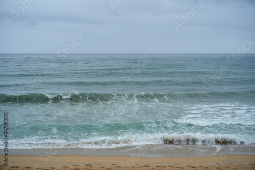 Scenic view of ocean waves crashing on a sandy beach. The tranquil scene evokes a sense of peace and relaxation, perfect for travel or nature-themed projects.