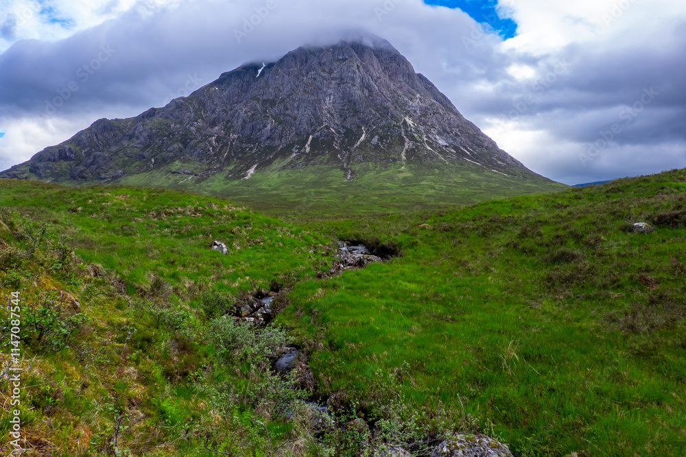 Fototapeta premium Small stream leading to mist covered mountain