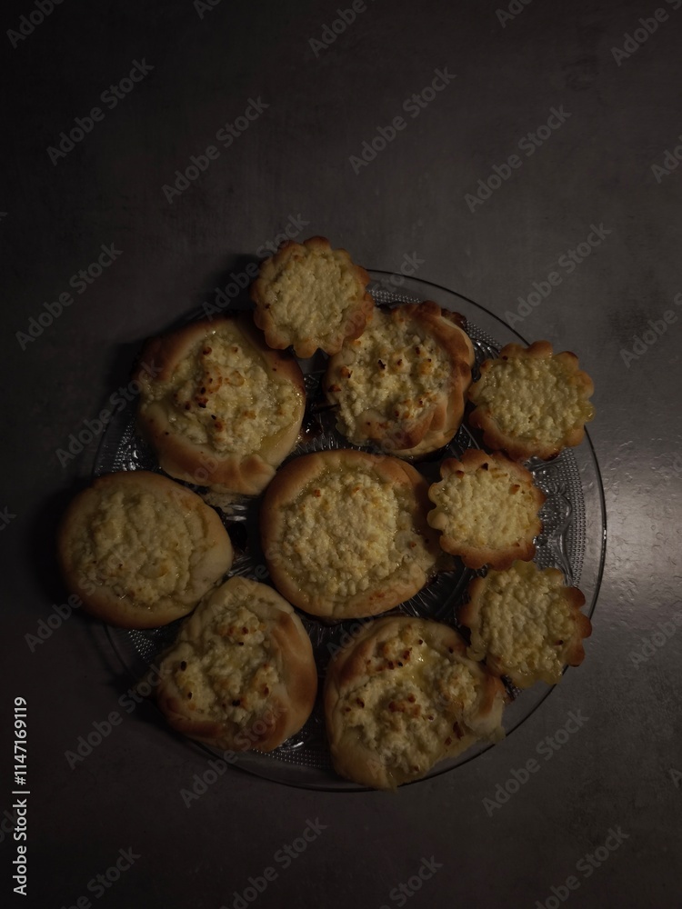 Fototapeta premium Delicious homemade pastries with cottage cheese filling resting on glass plate