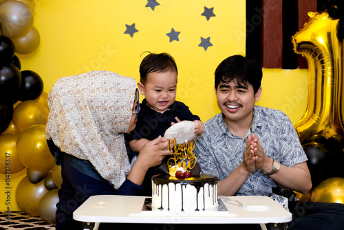 Baby boy with super cute expression. Small family celebrating her first son's birthday